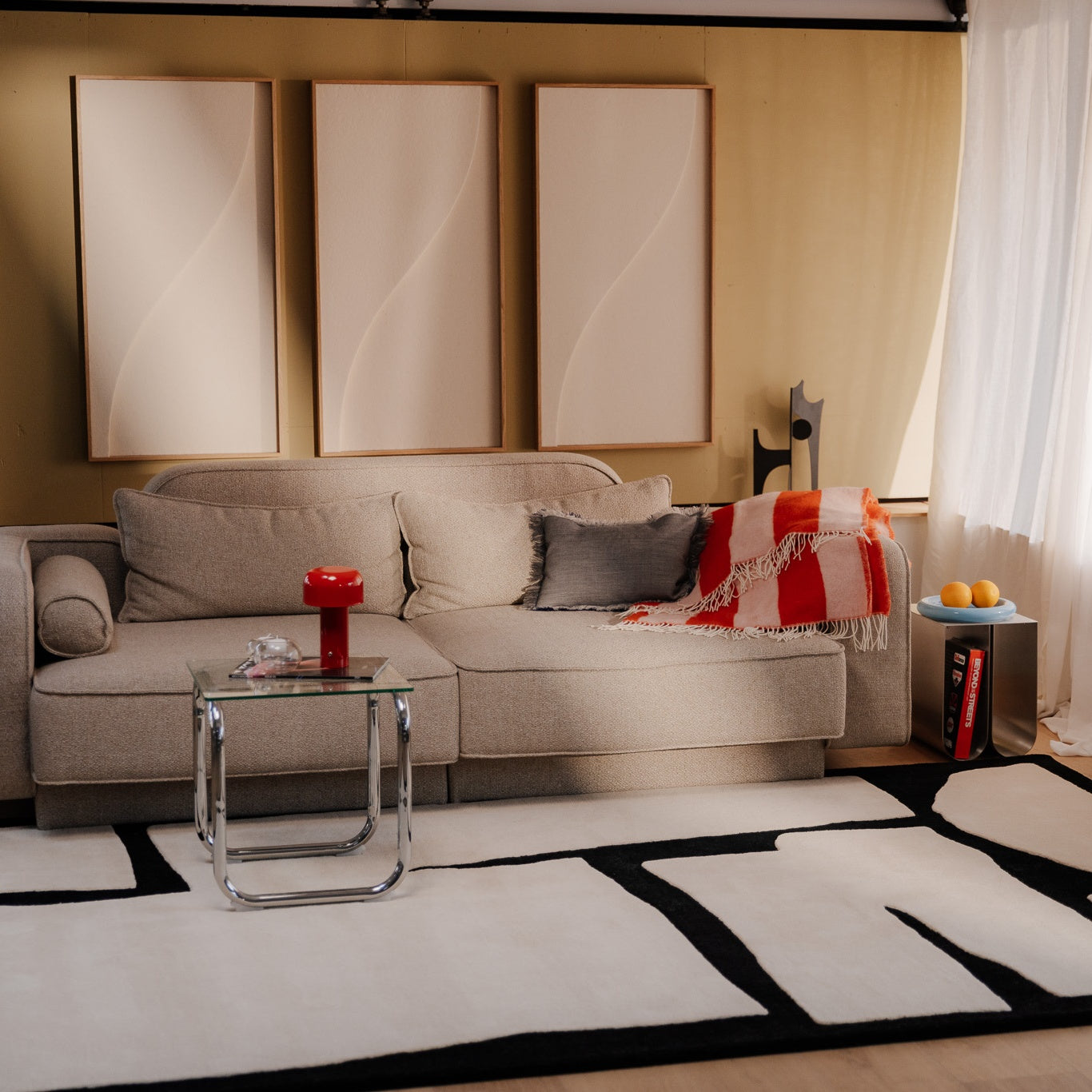 Practical acoustic design with beige wall panels, soft sofa, graphic rug and natural daylight interior